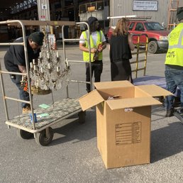 staff helping carry out antique chandelier