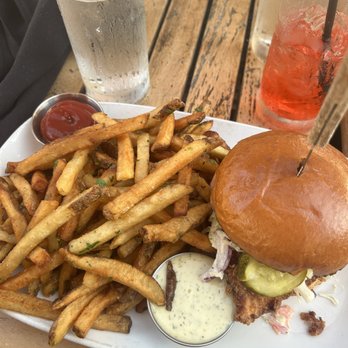 Sapphire - Crispy chicken sandwich (pickles, garlic dill aioli, coleslaw, and a challah bun paired with herb fries) - New American Near Me - Laguna Beach, California