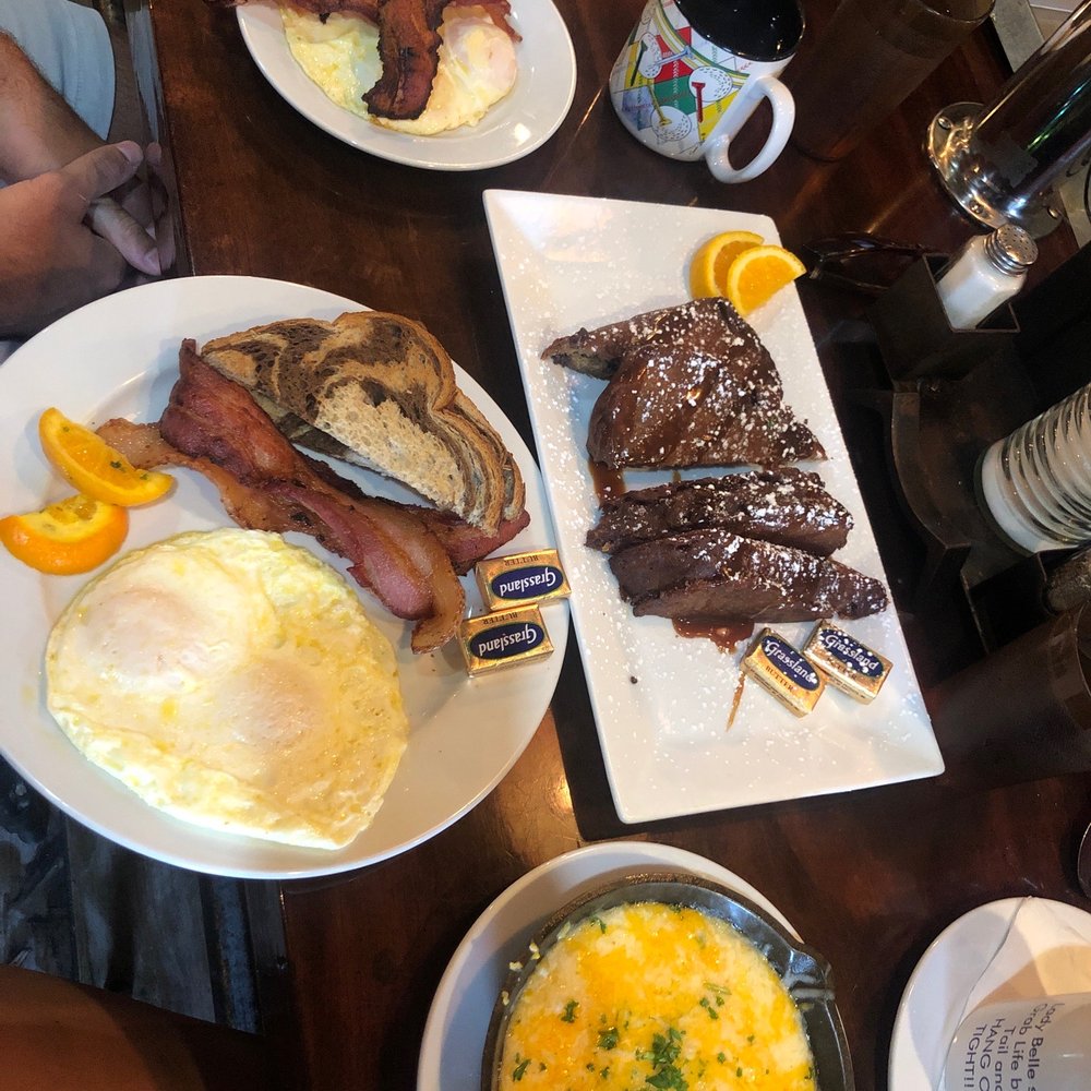 Backwater - Southern breakfast: 2 over easy eggs, bacon, grits & deep fried chocolate chip/banana bread French toast - Breakfast & Brunch Near Me - Melbourne, Florida Backwater - Southern breakfast: 2 over easy eggs, bacon, grits & deep fried chocolate chip/banana bread French toast - Breakfast & Brunch Near Me - Melbourne, Florida
