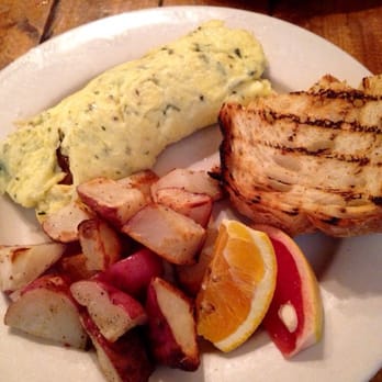 Americana - Herb omelet with goat cheese and caramelized onions. Roasted potatoes and sourdough bread toast - New American Near Me - Seattle, Washington Americana - Herb omelet with goat cheese and caramelized onions. Roasted potatoes and sourdough bread toast - New American Near Me - Seattle, Washington