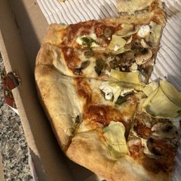 Two lightly topped, mostly undercooked bread, cold pizzas.