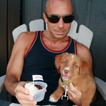 Mr. Arancino - a man sitting in a chair holding a dog and a bowl of ice cream - Food Trucks Near Me - Vancouver, British Columbia