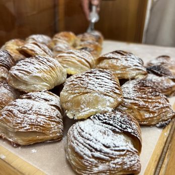 Bricco Panetteria - a person spreading powdered sugar on a pastry - Bakeries Near Me - Boston, Massachusetts