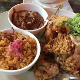 Chimichanga with beef short rib inside and guacamole on top. Rice and beans side dishes Chimichanga with beef short rib inside and guacamole on top. Rice and beans side dishes