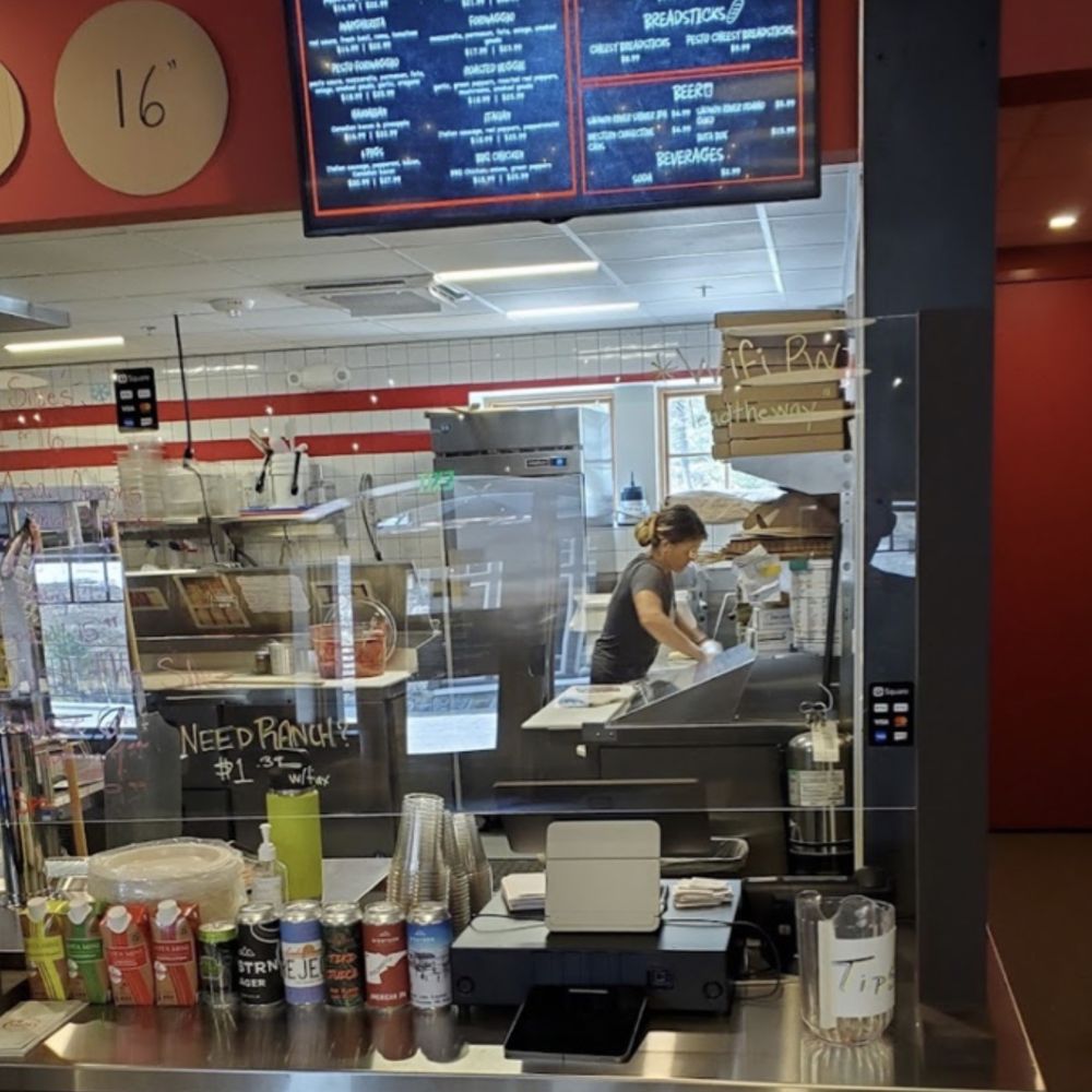 Crusty's Pizza - a woman working behind the counter - Pizza Near Me - Tamarack, Idaho
