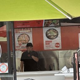 Guy grabbing toppings and eating it several times.