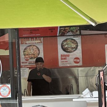 Mong Q - Guy grabbing toppings and eating it several times. - Mongolian Near Me - Orange, California