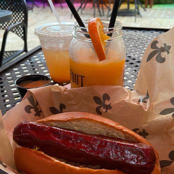 Oceanas Hideout Bar - Tang hurricane in take-home glass and burnt ends brisket hotdog. - Bars Near Me - New Orleans, Louisiana Oceanas Hideout Bar - Tang hurricane in take-home glass and burnt ends brisket hotdog. - Bars Near Me - New Orleans, Louisiana