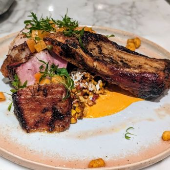 Tillie's - Ancho smoked pork chop - guajillo crema, elote succotash, and pickled persimmon (absolutely delicious!) - New American Near Me - Dripping Springs, Texas Tillie's - Ancho smoked pork chop - guajillo crema, elote succotash, and pickled persimmon (absolutely delicious!) - New American Near Me - Dripping Springs, Texas