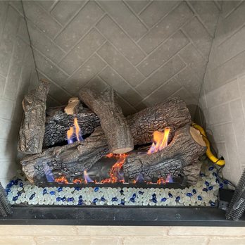 Sixpenny Chimney Sweeps - Gas log set burning over a bed of white and blue decorative fire glass, set against a herringbone-pattern back panel in a hom... - Chimney Sweeps Near Me - Woodbridge, Virginia Sixpenny Chimney Sweeps - Gas log set burning over a bed of white and blue decorative fire glass, set against a herringbone-pattern back panel in a hom... - Chimney Sweeps Near Me - Woodbridge, Virginia