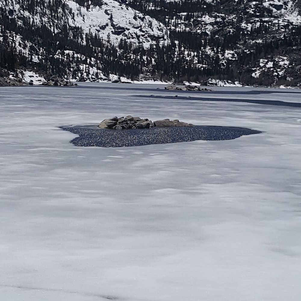 1/2 frozen lake. Surrounded by beautiful snow topped mountains. 1/2 frozen lake. Surrounded by beautiful snow topped mountains.