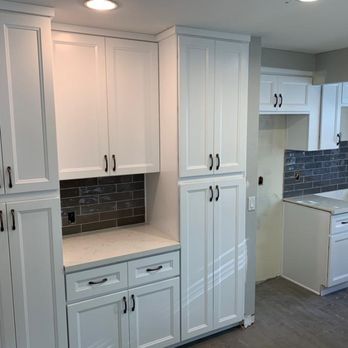 Nikki Construction - a kitchen with white cabinets and a black tile backsplash - General Contractors Near Me - Sherman Oaks, California Nikki Construction - a kitchen with white cabinets and a black tile backsplash - General Contractors Near Me - Sherman Oaks, California