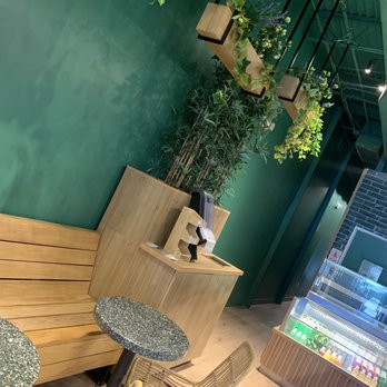 Smoothie Spot -Tamiami -  a green wall and a wooden bench - Juice Bars & Smoothies Near Me - Miami, Florida