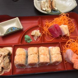 a tray of sushi and vegetables