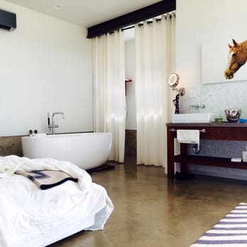 Rancho Loma - a bedroom with a bathtub and a giraffe head - New American Near Me - Valera, Texas