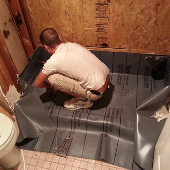 Kepper Construction - a man installing a bathroom floor - General Contractors Near Me