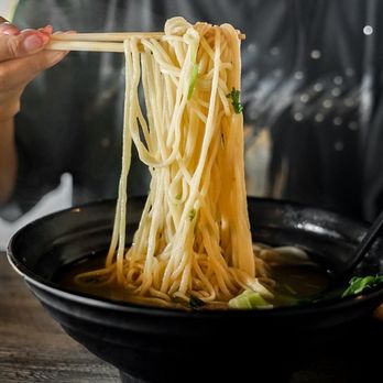 Kungfu Ramen - a woman holding chopsticks over a bowl of noodles - Noodles Near Me - Tempe, Arizona