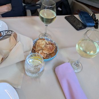 Lisbon Cafe Of Mineola - Complimentary bread and fresh potato chips. Two glasses of Vinho Verde (not complimentary lol) - Portuguese Near Me - Mineola, New York