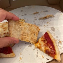 Beggars Pizza - The pizza dough that is not fresh. Note the little holes from the manufacturing process. This tastes like a giant export soda cracker.
