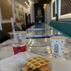 Bora Bora Smoothie Cafe - Waffle sandwich with smoked salmon, cream cheese, and capers featured. Pomegranate Refresher and Spanish latte are on the sides.