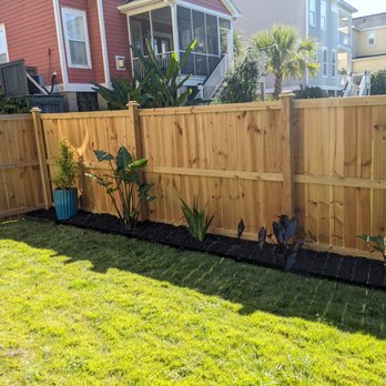 The Botanical Brothers - a wooden fence in a backyard - Landscaping Near Me