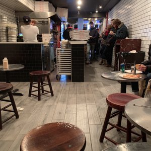 Photo of 2 Bros Pizza - New York, NY, United States. Inside seating and counter area
