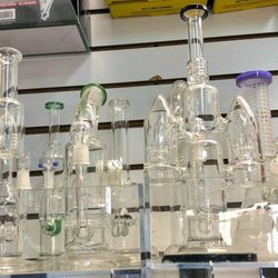 Tobacco Mart Madison WI - Glass water pipes, bongs & dab rigs displayed on wall rack | Head shop & smoke accessories on State St