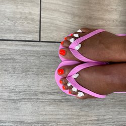 Pedicures feet with Color Club orange polish.