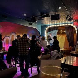 Sid Gold's Request Room - Folks clustered around the Piano man (Ben) with the next singer on the stage.