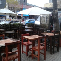 Voraz Pizza - Afuera del local hay mesas al aire libre y adentro tienen una barra pequeña.