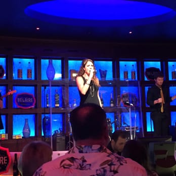 Blue Martini - a woman singing on stage in front of a group of people - Lounges Near Me - Lake Charles, Louisiana Blue Martini - a woman singing on stage in front of a group of people - Lounges Near Me - Lake Charles, Louisiana