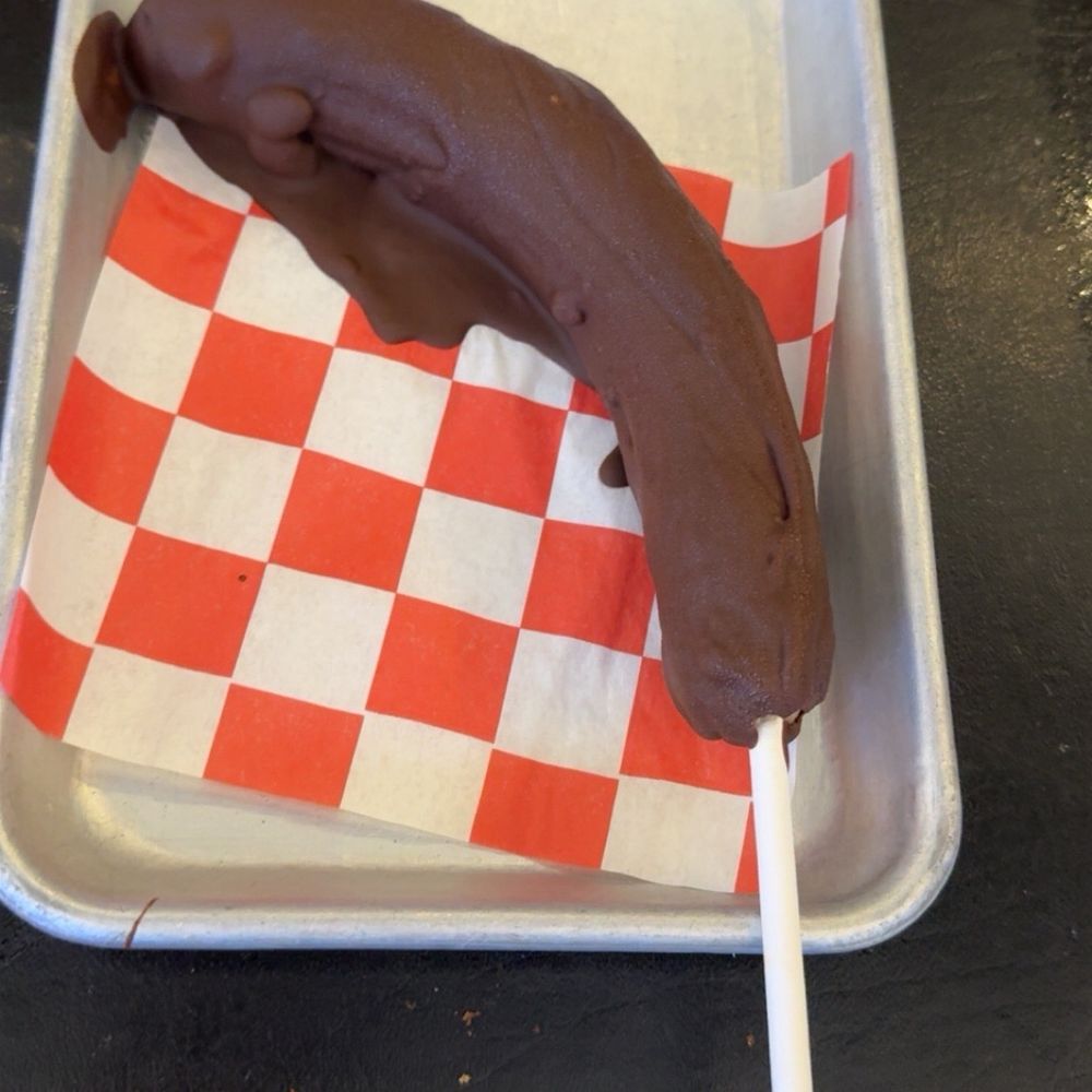 Clowndog Hot Dog Parlor - Frozen not so frozen banana dipped in chocolate ordered with peanuts, no peanuts - Hot Dogs Near Me - Albuquerque, New Mexico Clowndog Hot Dog Parlor - Frozen not so frozen banana dipped in chocolate ordered with peanuts, no peanuts - Hot Dogs Near Me - Albuquerque, New Mexico