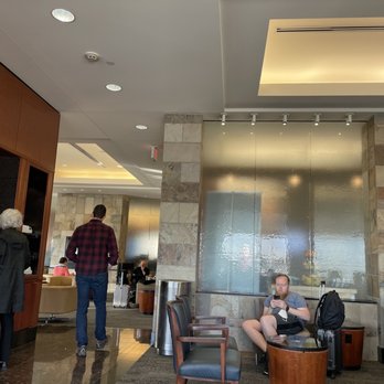 Delta Sky Club - a man sitting on a chair in the lobby - Airport Lounges Near Me - Saint Paul, Minnesota