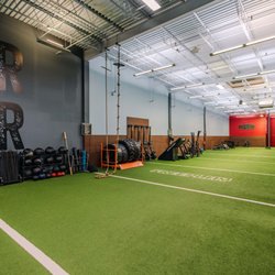 Spacious functional training zone at our Richmond gym featuring turf flooring, ropes, sleds, tires & strength training equipm...