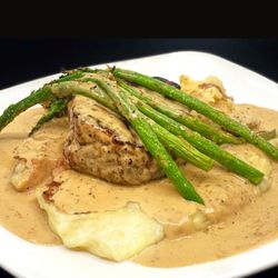 Maderas Steak & Ribs - 8oz Prime Scotts Peppercorn Filet on a bed of garlic mashed potatoes, topped with asparagus & our famous peppercorn sauce