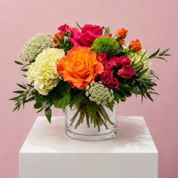 Wine & Blooms - Citrus Obsession is a vibrant arrangement bursting with lively pink and citrus-orange tones, designed to capture pure sunshine.