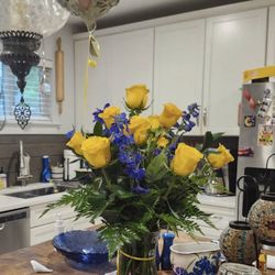 A Courtyard Florist - Dozen yellow roses with blue flowers and a Mother's Day mylar balloon. Custom order.