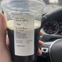 a hand holding a cup of cold brew a hand holding a cup of cold brew
