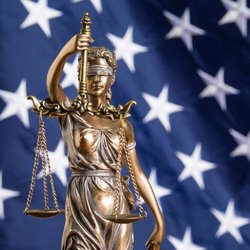 San Diego Workers' Compensation Attorney, Leslie Shaw - lady justice in front of the USA flag