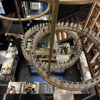 Rare Society - Bar below a large artistic structure with bottles of alcohol - Steakhouses Near Me - San Clemente, California Rare Society - Bar below a large artistic structure with bottles of alcohol - Steakhouses Near Me - San Clemente, California