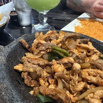 Tlaquepaque - Grande Molcajete with a lg margarita in the background. - Mexican Near Me - Brunswick, Ohio Tlaquepaque - Grande Molcajete with a lg margarita in the background. - Mexican Near Me - Brunswick, Ohio