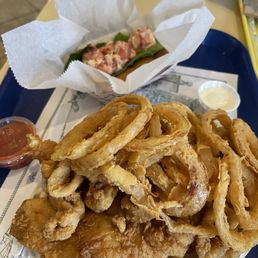 Fried combo meal with potatoes, onion rings, Calamari, and fish.