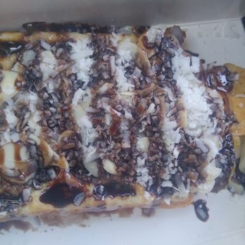 Bing Tea - Almond Joy waffle - A waffle with toppings including chocolate, white chocolate, caramel, and chopped nuts, served with a wooden stick. - Desserts Near Me - Albuquerque, New Mexico