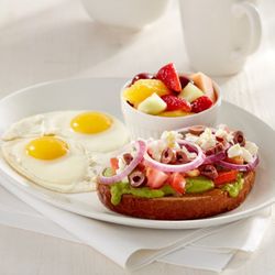 Sunset Grill - Avocado Toast served with two eggs and a ramekin of fresh cut fruit salad.
