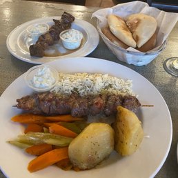 Lamb and chicken souvlaki with rice, potato, veg, pita and tzaziki Lamb and chicken souvlaki with rice, potato, veg, pita and tzaziki