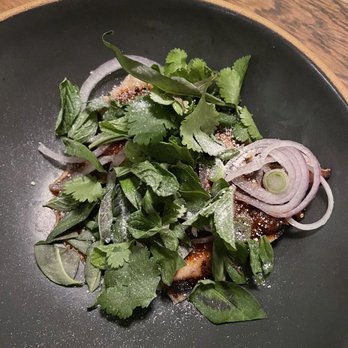 Nari - nom tok moo $42 ~ slow cooked pork chop finished on the grill, slathered in nim jaw jaew sauce, topped with herbs and toasted rice powder - Thai Near Me - San Francisco, California