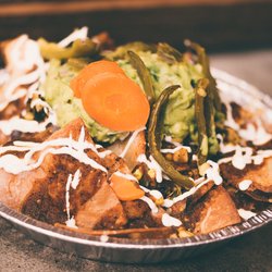 Tacoria's loaded nachos are piled high with crispy tortilla chips, seasoned protein, guacamole, queso, sour cream, jalapeños,...
