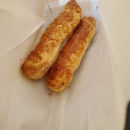 two breadsticks in a paper bag
