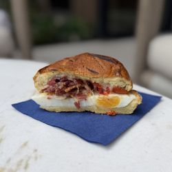 Elan Café - Brioche Breakfast Sandwich (egg, white cheddar, bacon, roasted tomato, lemon aioli; cut in half)