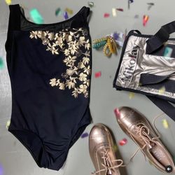 The Station - Black leotard and gold tap shoes.